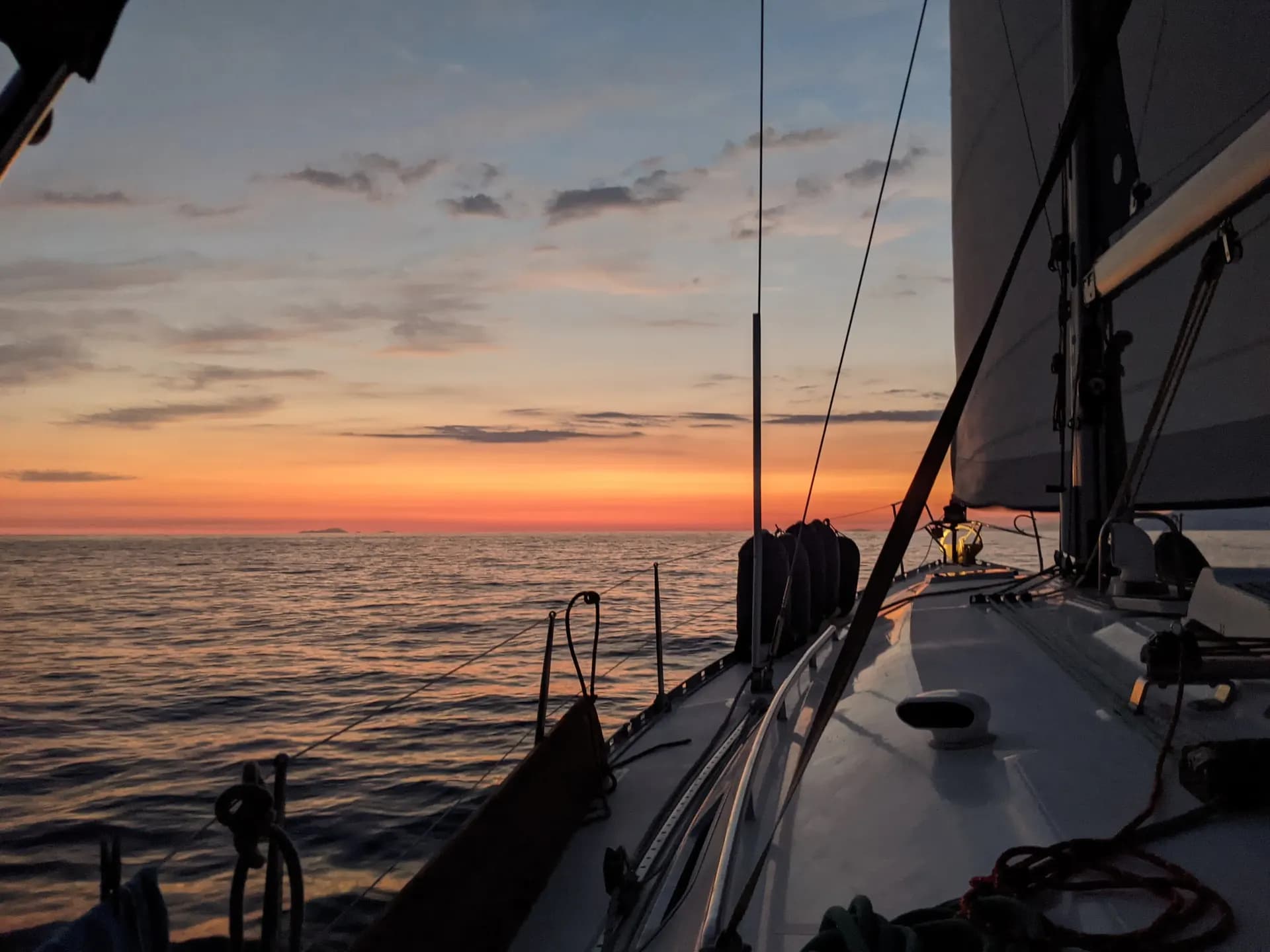 Sunset on the horizon from a monohull underway